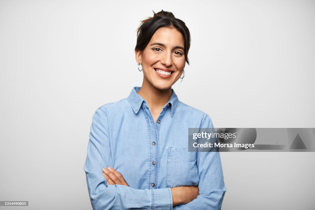 Confident Hispanic Woman Against Gray Background