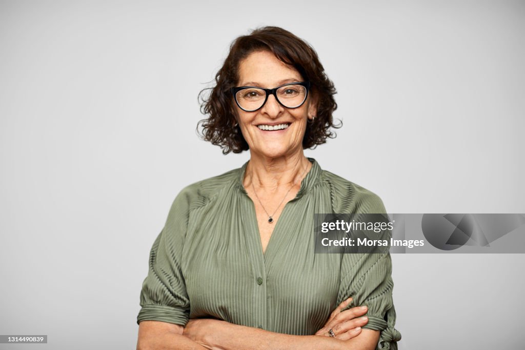 Smiling Elderly Hispanic Woman Against Gray Background