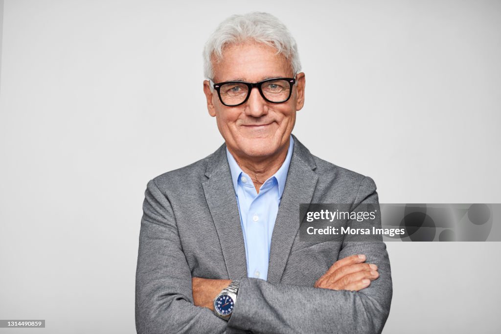 Confident Hispanic Businessman Against Gray Background