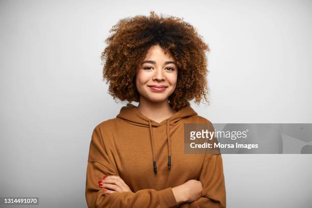 confident young woman against white background - formeel portret stockfoto's en -beelden