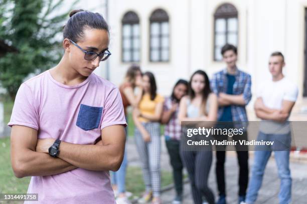 trauriger männlicher schüler von seinen klassenkameraden gebullt - druck durch gleichaltrige stock-fotos und bilder