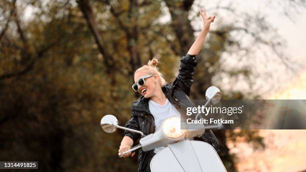 a young and beautiful blonde rides a scooter. - riding vespa stock pictures, royalty-free photos & images