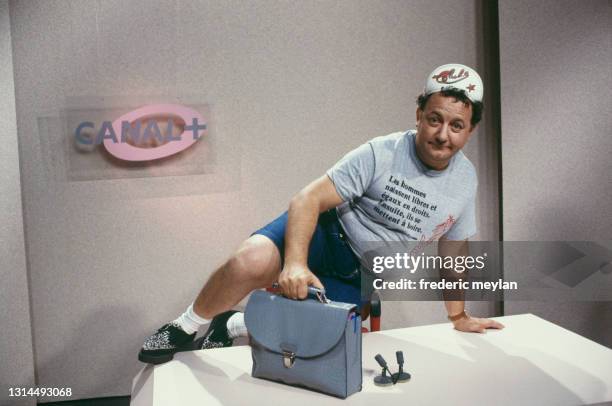 French humorist Coluche on the TV set of Canal Plus where he presents the news in comic form.