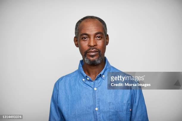 confident mature man against white background - portretfoto stockfoto's en -beelden