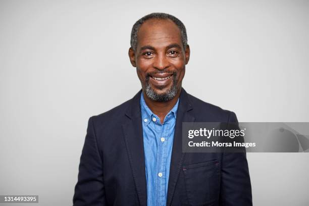 mature businessman against white background - black blazer foto e immagini stock