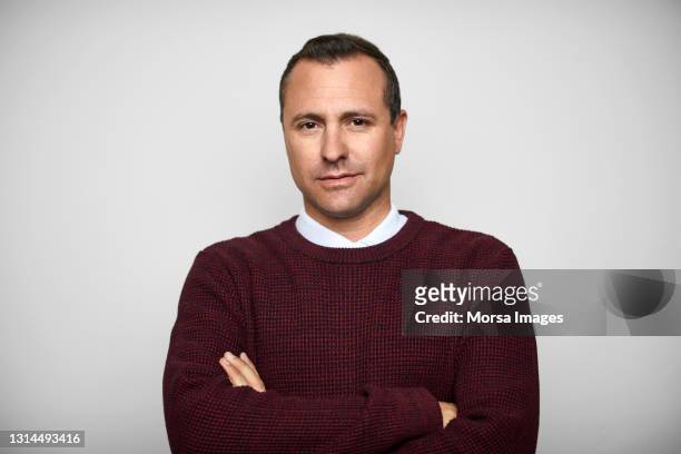 confident male in sweater against white background - mid adult stock pictures, royalty-free photos & images