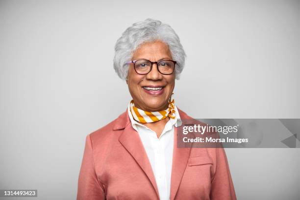 confident senior businesswoman against white background - grey hair cool woman stock-fotos und bilder