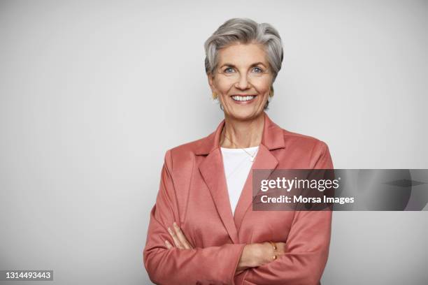 confident senior businesswoman against white background - grey blazer stock pictures, royalty-free photos & images