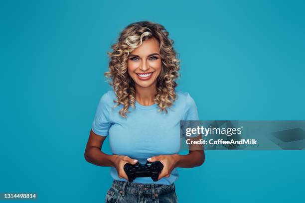 mujer sosteniendo joystick y jugando - gaming controller fotografías e imágenes de stock