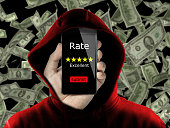 anonymous with hoodie making fake rating and review for money concept conceptual. Untrue feedback in exchange of dollars. Business online ranking is affected from false review by user to gain money.