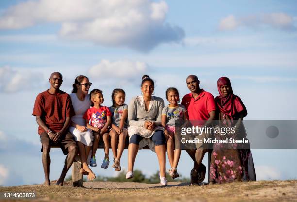 Mo Farah poses with his wife Tania, son Hussein, daughters Amani, Rhianna and Aisha, brother Hassan and mother Aisha at Frensham Great Pond on July...