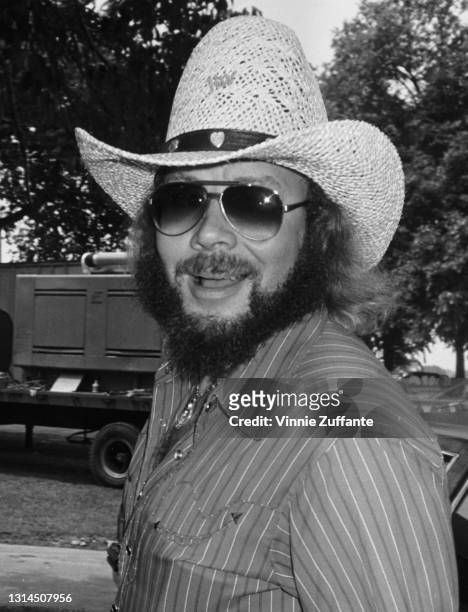 American singer-songwriter and musician Hank Williams Jr wearing a pair of sunglasses with gradient lenses and a straw cowboy hat attending an...