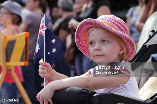 kleines mädchen winkt eine australische flagge - australia day celebrations stock-fotos und bilder