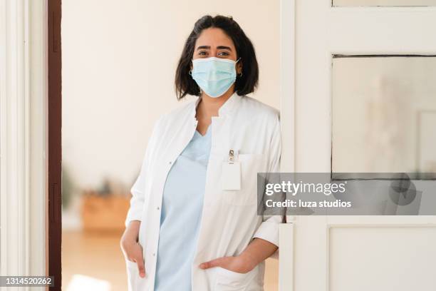 portrait of a happy medical doctor wearing a protective face mask - medical building stock pictures, royalty-free photos & images