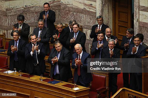 Greek Prime Minister George Papandreou and members of his government applaud after winning the confidence vote in the Greek parliament on November...