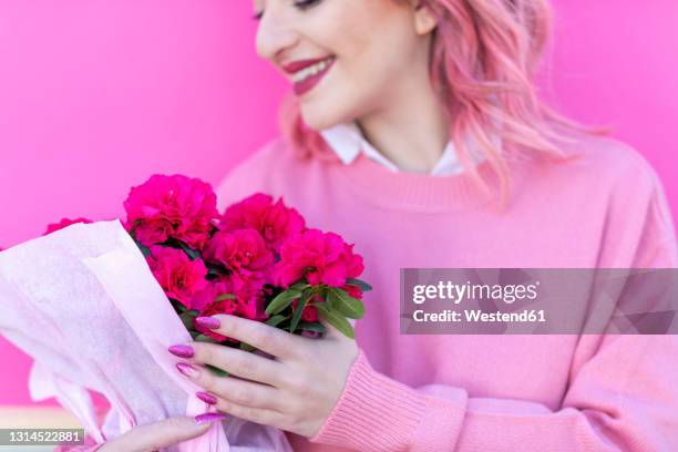 smiling woman holding fresh azalea flowers - azalea foto e immagini stock