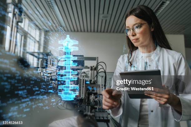 female engineer with digital tablet examining development of industrial product - vetenskapskvinna bildbanksfoton och bilder