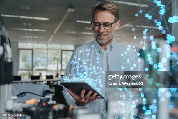 smiling male engineer with digital tablet working on networking project - engineer cad photos et images de collection