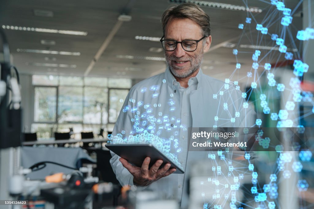 Smiling male engineer with digital tablet working on networking project