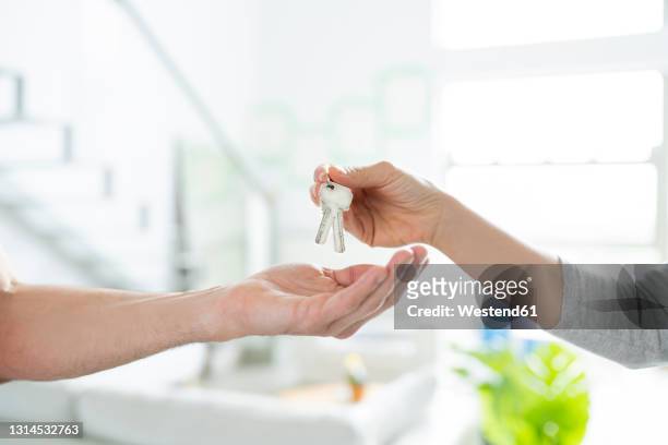 woman giving keys to man - house key hands stock pictures, royalty-free photos & images