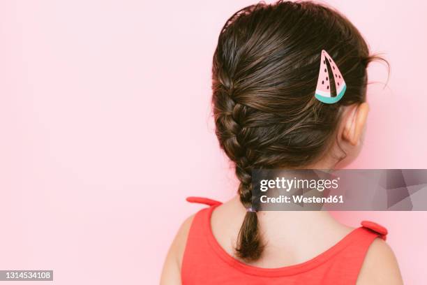 back view of little girl with braid and hair clip against pink background - hair accessory fotografías e imágenes de stock