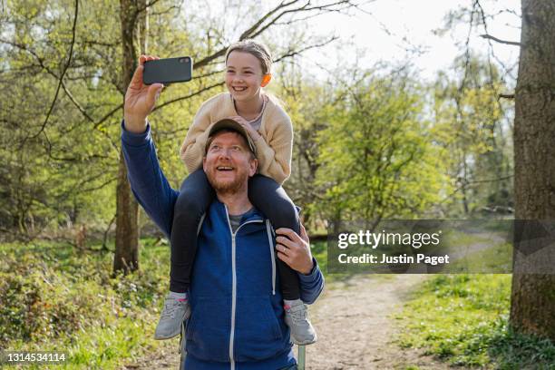 father and daughter selfie in the woods - family hiking in spring outdoors foto e immagini stock