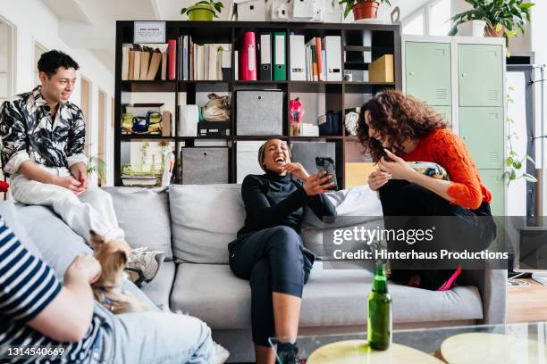 transgender woman laughing with work colleague - after work drinks stock-fotos und bilder