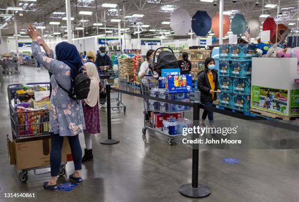 Honduran immigrant Nani helps her aunt shop at Sam's Club a day after the girl arrived to live with her extended family on April 25, 2021 near...