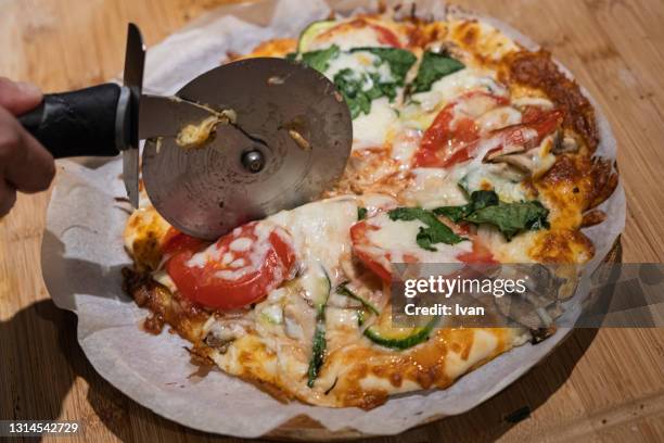 fresh baked pizza with cutter - catering stock-fotos und bilder