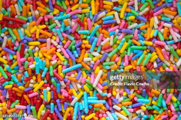 colorful sugar sprinkles filling the frame - rainbow confetti stock pictures, royalty-free photos & images