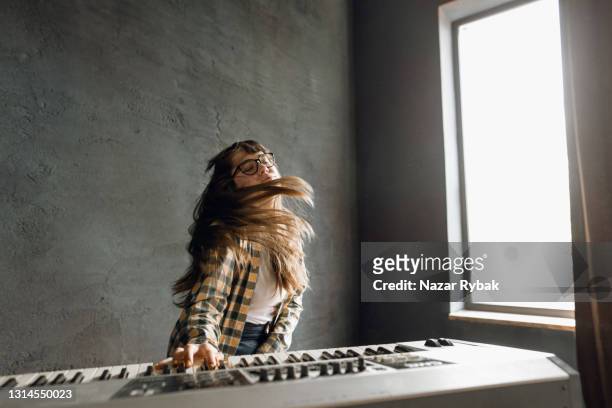 a young woman plays the synthesizer - pianist stock pictures, royalty-free photos & images