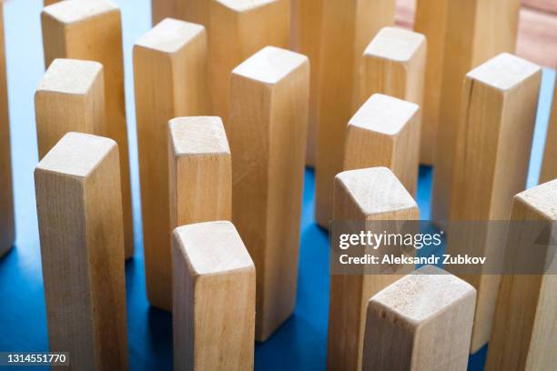 a pile of scattered wooden blocks on a blue background. construction game. the broken tower. - jenga tower stock pictures, royalty-free photos & images