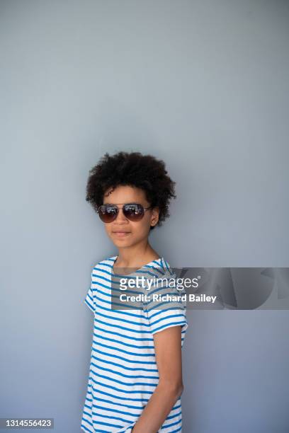 portrait of young boy wearing sunglasses against a plain background - jeans for boys stock pictures, royalty-free photos & images