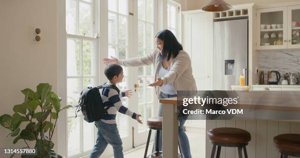 shot of a young mother bonding with her son at home while she packs his schoolbag - leaving school imagens e fotografias de stock
