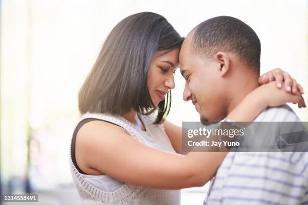 shot of a young couple embracing at home - slow dancing stock pictures, royalty-free photos & images