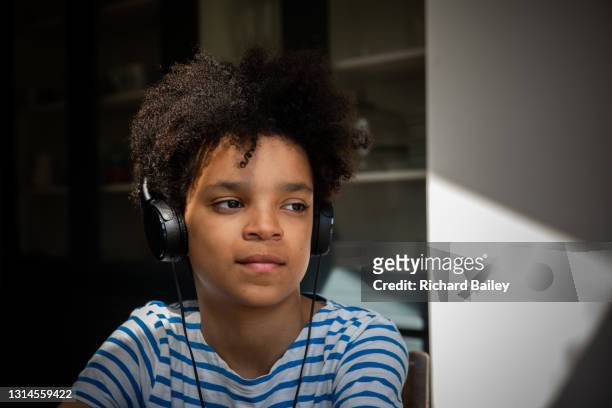 teenage boy wearing large headphones, listening to music - 13 year old cute boys stock pictures, royalty-free photos & images