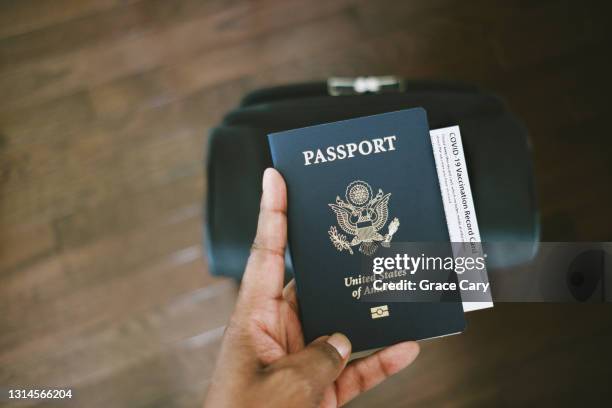 woman holds us passport with covid-19 vaccination card - pasaporte fotografías e imágenes de stock
