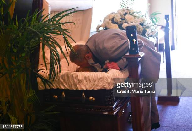 Mario Frausto kisses his deceased husband Terrance Sheppard, who passed away due to complications from COVID-19, amid an overflow of the deceased...