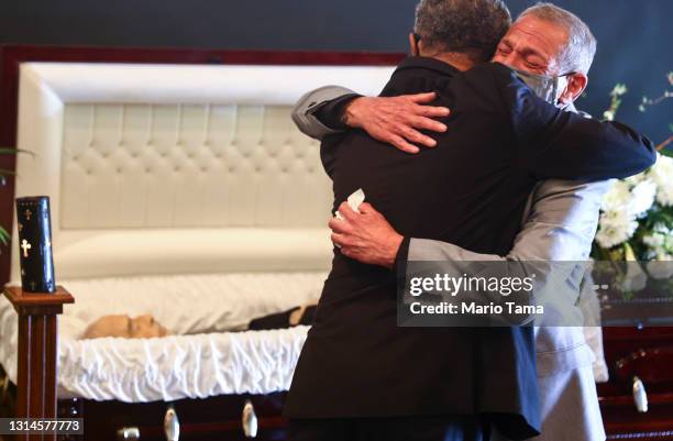 Mario Frausto embraces Dr. Michael C. Brown, minister, at the funeral for Frausto's husband Terrance Sheppard, who passed away due to COVID-19...