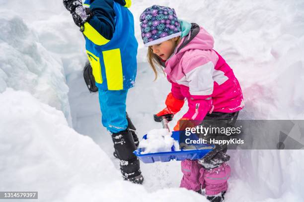 mädchen und junge schaufeln schnee - snow shovel stock-fotos und bilder