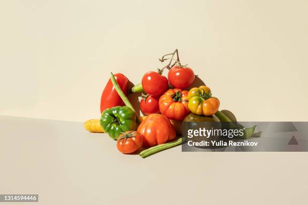 red,green tomatoes, carrots and green beans on the beige background - still life foto e immagini stock