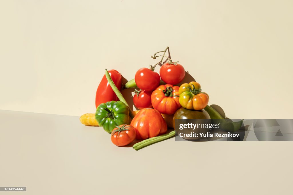 Red,green tomatoes, carrots and green beans on the beige background