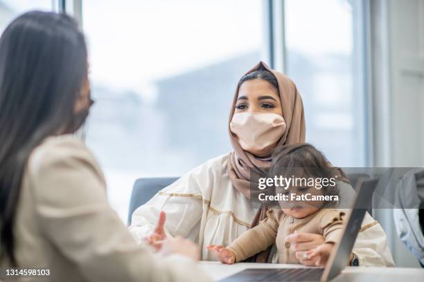 female muslim immigrant meeting with a financial planner - islamic finance stock pictures, royalty-free photos & images