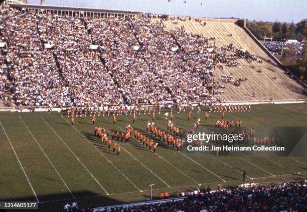 35mm film photo shows a marching band on the field at Iowa Stadium at a college football game against Wisconsin, 1940.