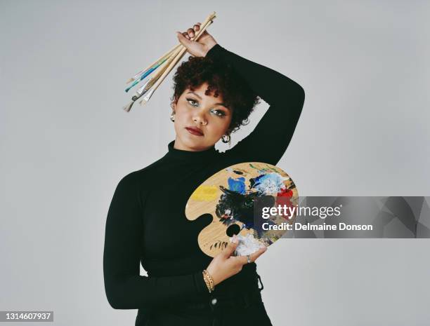 cropped portrait of an attractive young artist standing alone in her studio while holding an art palette and paintbrushes - artist palette stock pictures, royalty-free photos & images