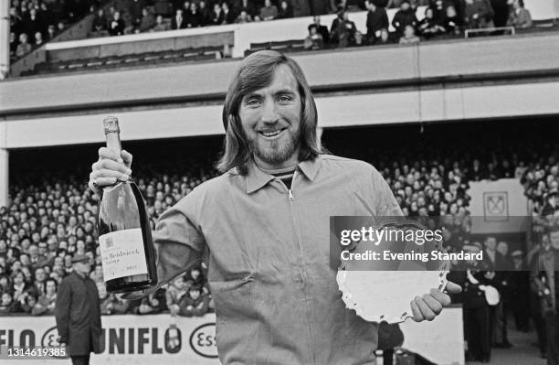 English footballer Billy Bonds of West Ham United FC is awarded the Evening Standard Footballer of the Month trophy and a bottle of Charles Heidsieck...