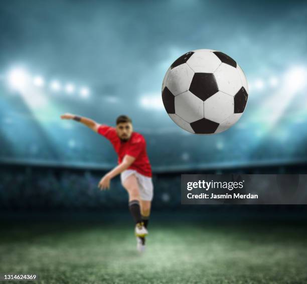 soccer player kicking the ball at night stadium - american football field photos et images de collection