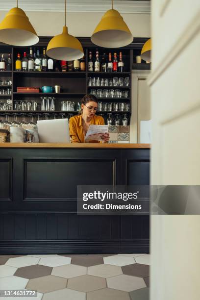 female restaurant manager checking bills - overworked waitress stock pictures, royalty-free photos & images