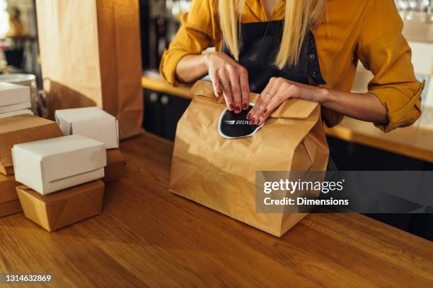 primer plano de la mujer empacando comida para el parto - entregando fotografías e imágenes de stock