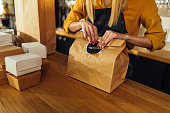 Close up of woman packing food for delivery